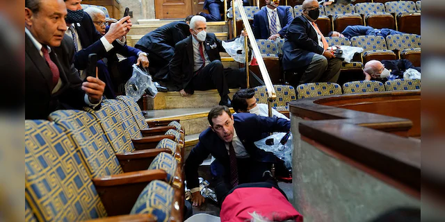 People shelter in the House gallery as protesters try to break into the House Chamber at the U.S. Capitol on Wednesday, Jan. 6, 2021, in Washington. (Associated Press)