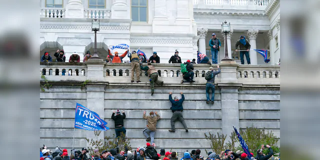 Supporters of President Donald Trump climb the west wall of the the U.S. Capitol on Wednesday, Jan. 6, 2021, in Washington. (Associated Press)