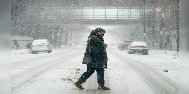 A pedestrian crosses a snow covered street on Monday in downtown Des Moines, Iowa. (AP)