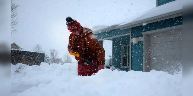 Tim Ahlman shovels snow outside his home in Bellemont, Ariz. on Monday. (AP)