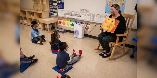 In this Jan. 11 file photo, pre-kindergarten teacher Angela Panush reads a story to her students at Dawes Elementary in Chicago. Some parents have suggested they will sue to force teachers to return to classrooms for in-person instruction. (Ashlee Rezin Garcia/Chicago Sun-Times via AP, Pool File)