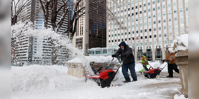 A worker uses a snowplow to shovel snow at Chicago's Millennium Park on Monday after a weekend-long winter storm dumped about a foot of snow in the greater Chicago area. (AP)
