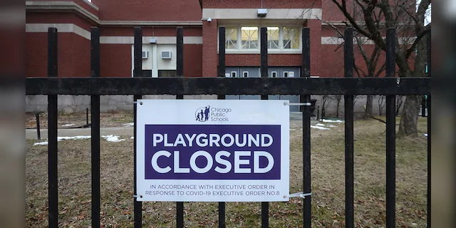 A sign outside of Columbus Elementary School lets visitors know that the playground has been closed on January 25, 2021 in Chicago, Illinois. (Photo by Scott Olson/Getty Images)