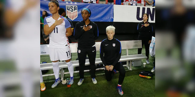 In this Sunday, Sept. 18, 2016, file photo, the United States' Megan Rapinoe, right, kneels next to teammates Ali Krieger (11) and Crystal Dunn (16) as the U.S. national anthem is played before an exhibition soccer match against the Netherlands in Atlanta. (AP Photo/John Bazemore, File)