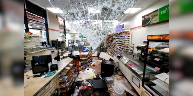 Shattered glass hangs from the doorway of a 7-Eleven store May 31, 2020, in Chicago. (AP Photo/Charles Rex Arbogast)