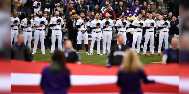 The Colorado Rockies line up before the national anthem.