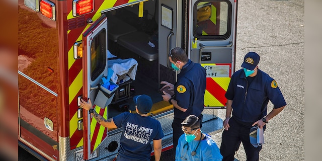 After administering him with oxygen, County of Los Angeles paramedics load a potential COVID-19 patient in the ambulance before transporting him to a hospital in Hawthorne, California on December 29, 2020. (Photo by APU GOMES/AFP via Getty Images)