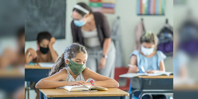 12-year-old girl wearing a reusable, protective face mask in classroom. (iStock)