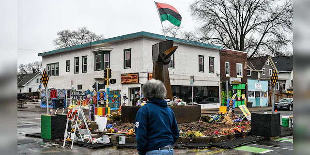 A man walks near the makeshift memorial of George Floyd before the third day of jury selection begins in the trial of former Minneapolis Police officer Derek Chauvin who is accused of killing Floyd, in Minneapolis, Minnesota on March 10, 2021. (Photo by CHANDAN KHANNA/AFP via Getty Images)