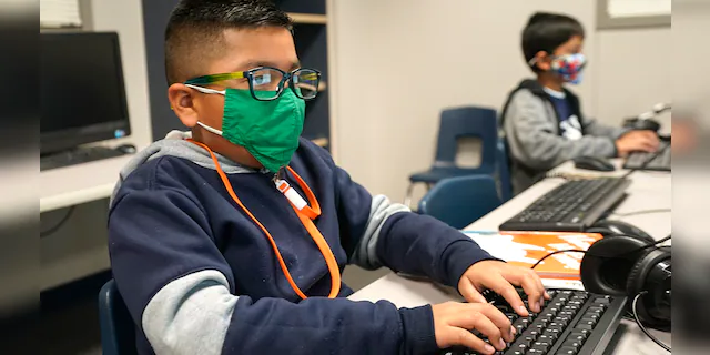 FILE - In this Dec. 3, 2020, file photo, students wearing face masks work on computers at Tibbals Elementary School in Murphy, Texas. (AP Photo/LM Otero, File)
