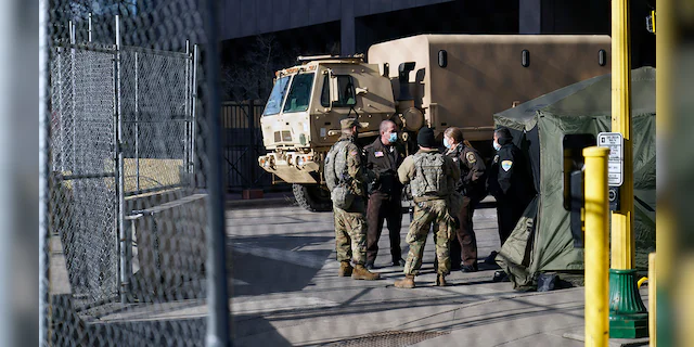 Deputies and National Guard soldiers converse, Tuesday, March 9, 2021, in Minneapolis where the trial for former Minneapolis police officer Derek Chauvin continues with jury selection. Chauvin is charged with murder in the death of George Floyd during an arrest last may in Minneapolis. AP Photo/Jim Mone)