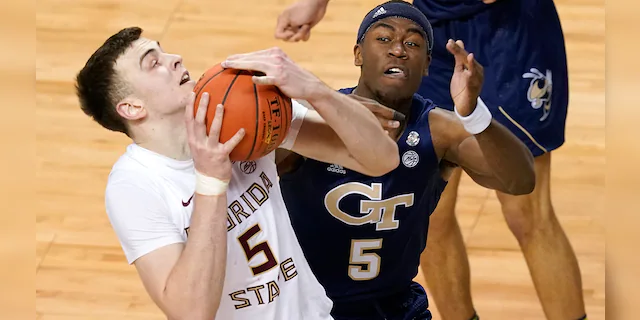 Georgia Tech forward Moses Wright (5) defends as Florida State center Balsa Koprivica (5) heads to the basket during the first half of an NCAA college basketball Championship game of the Atlantic Coast Conference tournament in Greensboro, N.C., Saturday, March 13, 2021. (AP Photo/Gerry Broome)
