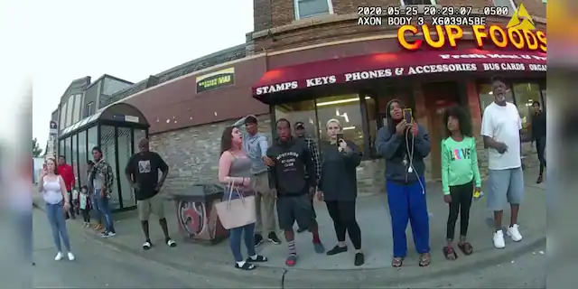 This image from a police body camera shows people gathering as former Minneapolis police officer Derek Chauvin was recorded pressing his knee on George Floyd's neck for several minutes as onlookers yelled at Chauvin to get off and Floyd saying that he couldn't breathe on May 25, 2020 in Minneapolis. Both Frazier and Williams are present. (Minneapolis Police Department via AP)
