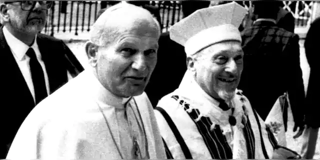 Pope John Paul II is escorted by Rome's Chief Rabbi Elio Toaff as they enter a Synagogue in Rome, Italy on April 13, 1986. It was the first recorded visit by a Pope to a Synagogue. (AP Photo)