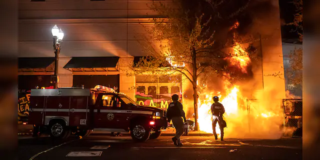 Portland Police and fire crews respond to a structure fire, set by protesters following the police shooting of a homeless man on April 17, 2021 in Portland, Oregon. (Photo by Nathan Howard/Getty Images)