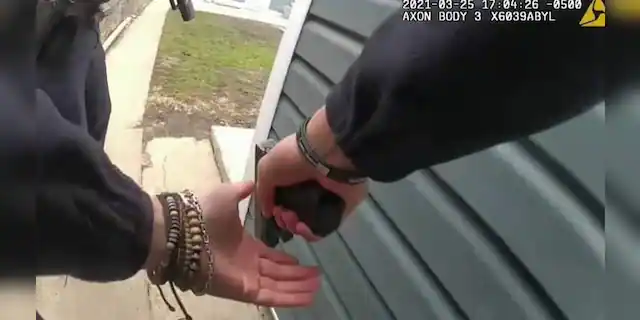 A Chicago police officer is seen with weapon in hand during the pursuit of a suspect in an image captured from a bodycam video.