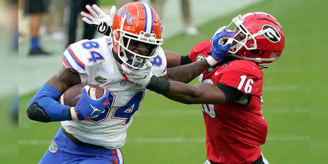 Florida tight end Kyle Pitts (84) tries to get past Georgia defensive back Lewis Cine (16) after a reception during the first half of an NCAA college football game in Jacksonville, Fla., in this Saturday, Nov. 7, 2020, file photo. (AP Photo/John Raoux, File)