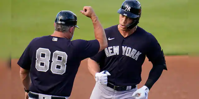 New York Yankees' Aaron Judge, right, rounds third to greetings from coach Phil Nevin after hitting a two-run home run off Philadelphia Phillies starting pitcher Matt Moore during the first inning of a spring training baseball game in Clearwater, Fla., Thursday, March 25, 2021. (AP Photo/Gene J. Puskar)