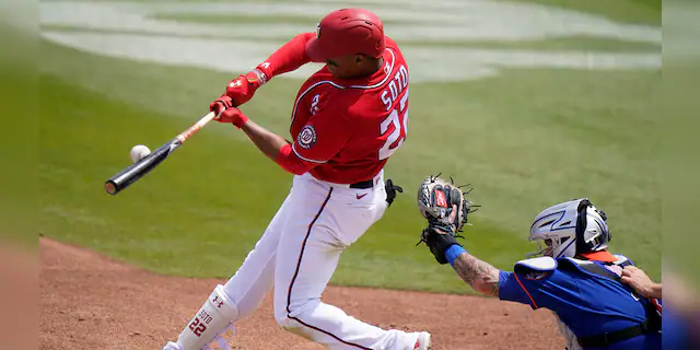 Washington Nationals' Juan Soto flies out to center field during the first inning of a spring training baseball game against the New York Mets, Sunday, March 21, 2021, in West Palm Beach, Fla. (AP Photo/Lynne Sladky)