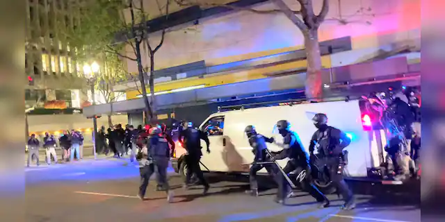 Riot police run towards protesters in Portland, Oregon, U.S. April 16, 2021, in this still image taken from a video. Grace Morgan via REUTERS THIS IMAGE HAS BEEN SUPPLIED BY A THIRD PARTY. MANDATORY CREDIT. NO RESALES. NO ARCHIVES.