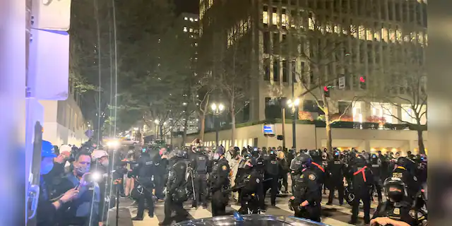 Riot police members stand guard during protests in Portland, Oregon, U.S. April 16, 2021, in this still image taken from a video. Grace Morgan via REUTERS THIS IMAGE HAS BEEN SUPPLIED BY A THIRD PARTY. MANDATORY CREDIT. NO RESALES. NO ARCHIVES.