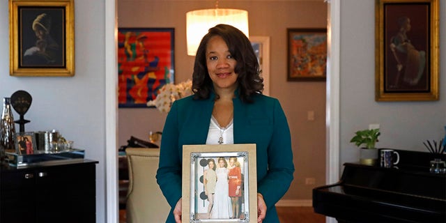 Robin Rue Simmons, alderwoman of Evanston's 5th Ward poses for a portrait holding a photograph of her mother, aunt and grandmother in her home in Evanston, Ill., Friday, April 9, 2021. 