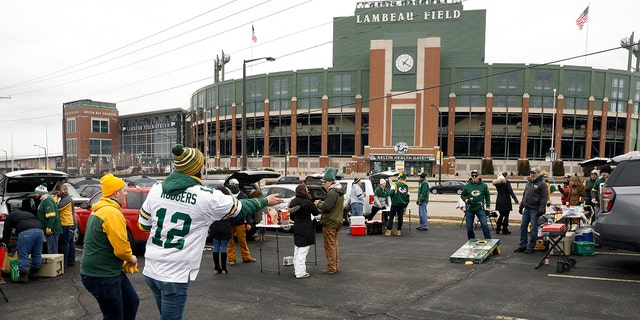 Fans toss bean bags outside of Lambeau Field before an NFL divisional playoff football game between the Los Angeles Rams and Green Bay Packers, Saturday, Jan. 16, 2021, in Green Bay, Wis. (AP Photo/Mike Roemer)