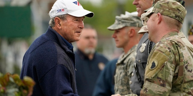 Former President George W. Bush thanks members of the American Legion Post 159 firing squad after a Memorial Day service in Kennebunkport, Maine, Monday, May 31, 2021. (AP Photo/Robert F. Bukaty)