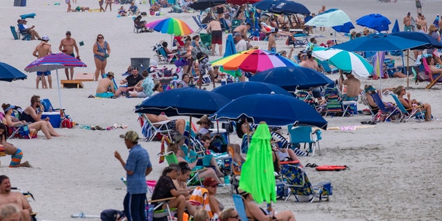 Beachgoers gather in the Cherry Grove section of North Myrtle Beach, S.C., Saturday, May 29, 2021. (Jason Lee/The Sun News via AP)