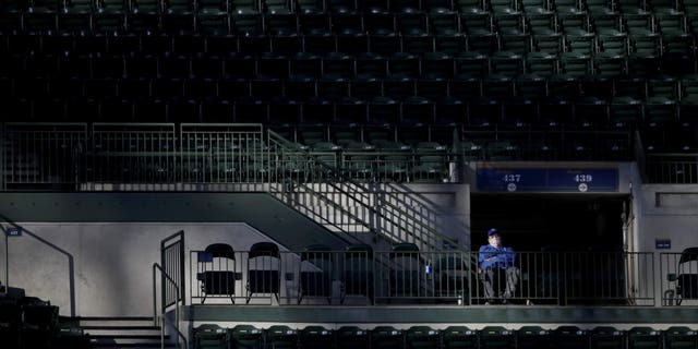 A fan watches from the stands during the second inning of a baseball game between the Milwaukee Brewers and the St. Louis Cardinals on Tuesday, May 11, 2021, in Milwaukee. (AP Photo/Aaron Gash)