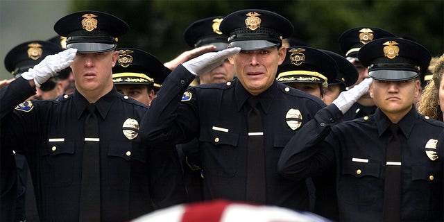 Burbank police officers salute the casket of their slain colleague Matthew Pavelka during funeral services at Forest Lawn Cemetary in Los Angeles Friday. Officer Pavelka was shot and killed while making a routine traffic stop.