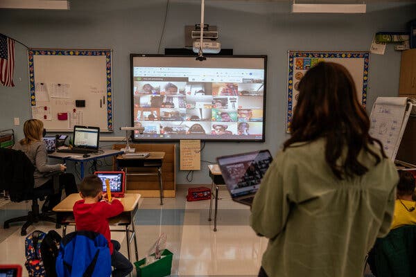 Students participating in a math activity in a first-grade class while their remote classmates were projected on a screen at James Monroe Elementary School in Edison, N.J., in November.