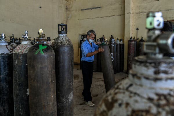 Workers moved oxygen cylinders for transport at a factory in New Delhi on Sunday. The city has now received enough oxygen to share its supply.