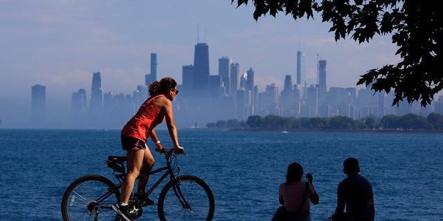 People spend time as they take advantage of warm summer weather along Lake Michigan, Wednesday, June 9, 2021 in Montrose Beach in Chicago. The beaches in Chicago have reopened since closing over a year ago because of the coronavirus pandemic. (AP Photo/Shafkat Anowar)
