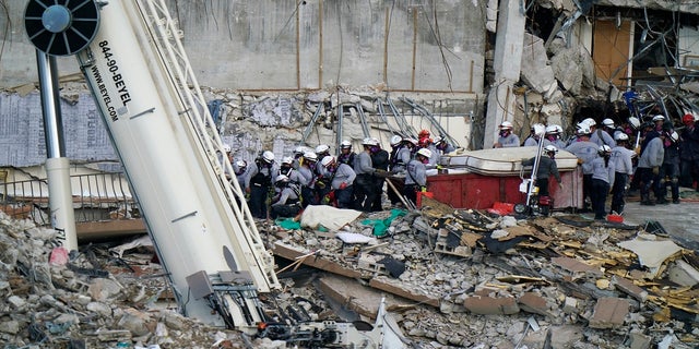 Workers search the rubble at the Champlain Towers South Condo on Monday. (AP)