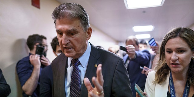 Sen. Joe Manchin, D-W.Va., a crucial 50th vote for Democrats on President Biden's proposals, walks with reporters as senators go to the chamber for votes ahead of the approaching Memorial Day recess, at the Capitol in Washington, Thursday, May 27, 2021. (AP Photo/J. Scott Applewhite)