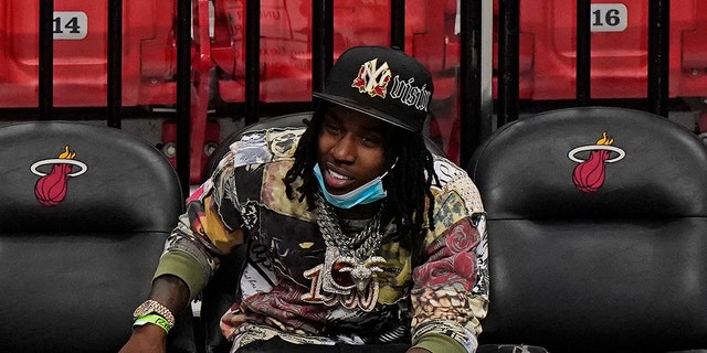 In this April 18, 2021 photo, Rapper Polo G watches during the second half of an NBA basketball game between the Miami Heat and the Brooklyn Nets in Miami.  Officials say rapper Polo G has been arrested in Miami on charges including battery on a police officer, resisting arrest with violence and criminal mischief. Jail records show 22-year-old Taurus Bartlett was booked into jail on Saturday, June 12, 2021.