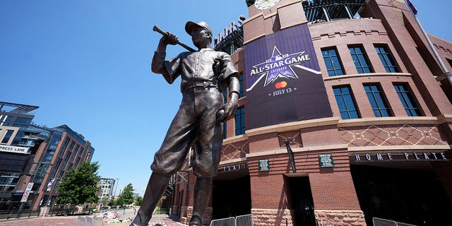 A banner for the All-Star game hangs on the front of Coors Field near the sculpture entitled "The Player" after a news conference to kick off All-Star week Wednesday, July 7, 2021, in Denver. (AP Photo/David Zalubowski)