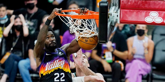 Phoenix Suns center Deandre Ayton (22) dunks against Milwaukee Bucks center Brook Lopez (11) during the second half of Game 1 of basketball's NBA Finals, Tuesday, July 6, 2021, in Phoenix. (AP Photo/Ross D. Franklin)