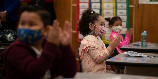 First graders applaud while listening to their teach in a classroom on the first day of in-person learning at Heliotrope Avenue Elementary School in Maywood, California, Tuesday, April 13, 2021. (AP Photo/Jae C. Hong)