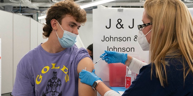 In this July 30, 2021, file photo, Bradley Sharp, of Saratoga, N.Y., gets the Johnson &amp; Johnson vaccine from registered nurse Stephanie Wagner in New York. Sharp needs the vaccination because it is required by his college. Hundreds of college campuses across the country have told students that they must be fully vaccinated against COVID-19 before classes begin in a matter of weeks. (AP Photo/Mark Lennihan, File)