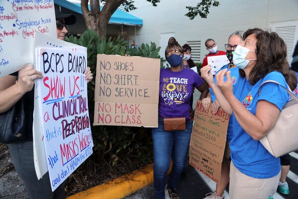 Teachers speak with anti-mask protesters about mask mandates outside of a Broward County School Board meeting, in Fort Lauderdale, Fla., last week.