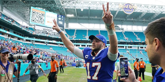 Buffalo Bills quarterback Josh Allen (17) raises his arms at the end of an NFL football game against the Miami Dolphins, Sunday, Sept. 19, 2021, in Miami Gardens, Florida. The Bills defeated the Dolphins 35-0. (AP Photo/Hans Deryk)
