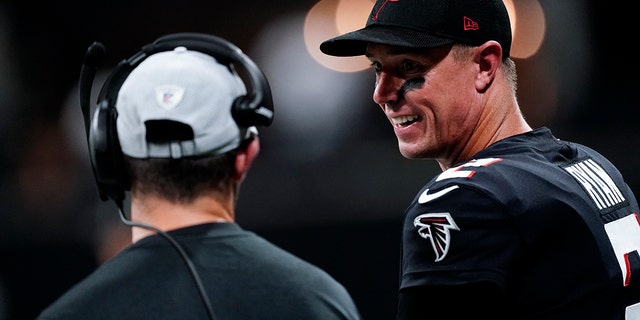Atlanta Falcons quarterback Matt Ryan, right, stands on the sidelines during the first half of a preseason NFL football game against the Cleveland Browns, Sunday, Aug. 29, 2021, in Atlanta. (AP Photo/John Bazemore)