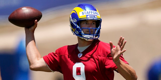 In this June 4, 2021, file photo, Los Angeles Rams quarterback Matthew Stafford passes during an NFL football practice in Thousand Oaks, Calif. With trips to the Super Bowl still in their recent memories, the Rams and the San Francisco 49ers made the decision this offseason that they needed more dynamic quarterback play to remain contenders in the long run. That led both NFC West rivals to make aggressive moves, trading multiple first-round picks to bring Stafford to Los Angeles and rookie Trey Lance to San Francisco. (AP Photo/Mark J. Terrill, File)