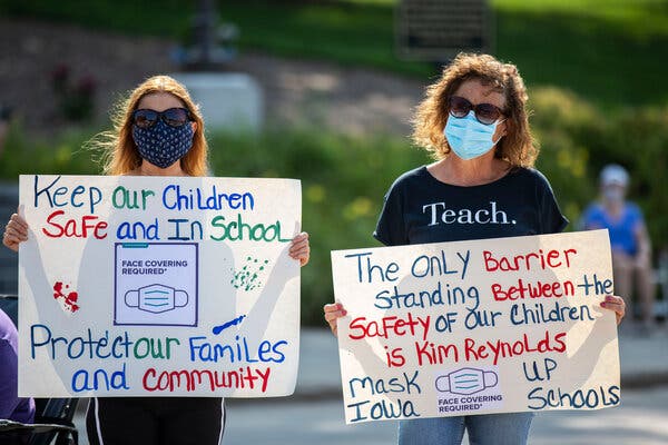Carla McIntire and Camille Johnson, both of Urbandale, Iowa, at a rally last month opposing a state law banning local governments and school districts from implementing mask mandates.