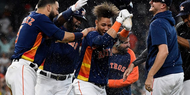 Houston Astros' Yuli Gurriel, center, celebrates his winning hit during the ninth inning of a baseball game against the Oakland Athletics, Sunday, Oct. 3, 2021, in Houston.