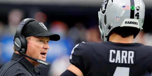 Head coach Jon Gruden of the Las Vegas Raiders talks with quarterback Derek Carr #4 during their game against the Miami Dolphins at Allegiant Stadium on Sept. 26, 2021 in Las Vegas, Nevada. The Raiders defeated the Dolphins 31-28 in overtime. 