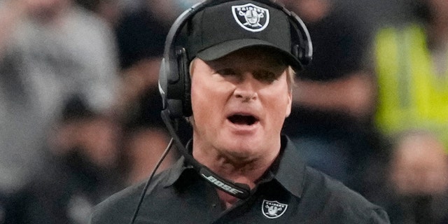 Las Vegas Raiders head coach Jon Gruden, left, speaks with an official during the first half of an NFL preseason football game against the Seattle Seahawks, Saturday, Aug. 14, 2021, in Las Vegas. 