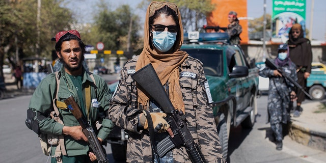 Taliban fighters stand guard during women's protest in Kabul, Afghanistan, Thursday, Oct. 21, 2021. 